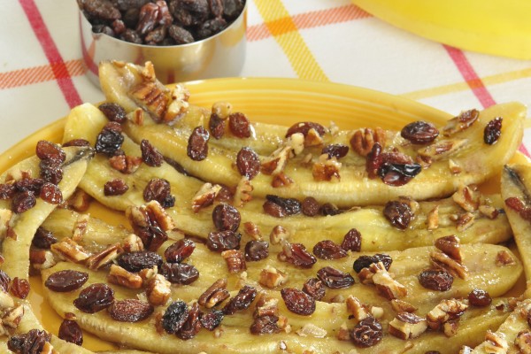Baked bananas topped with raisins and chopped nuts